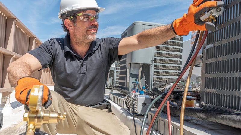 Technician working on commercial HVAC system